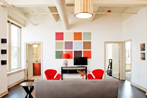 A living room with a grey couch and a red chair at 100 South Apartments, New York